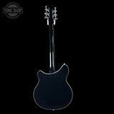 Back view of a black electric guitar with 'Tone Shop' logo.