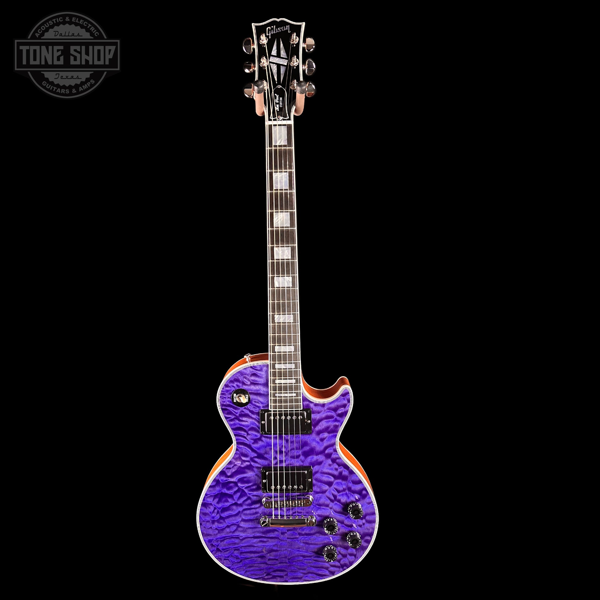 Purple electric guitar with a textured finish on a black background, featuring 'Tone Shop' logo.