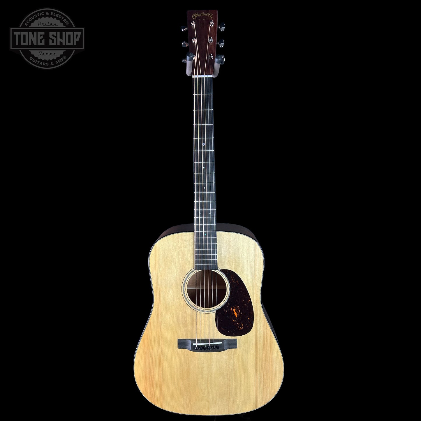 Acoustic guitar with a visible brand logo on a black background