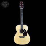 Acoustic guitar with a visible brand logo on a black background
