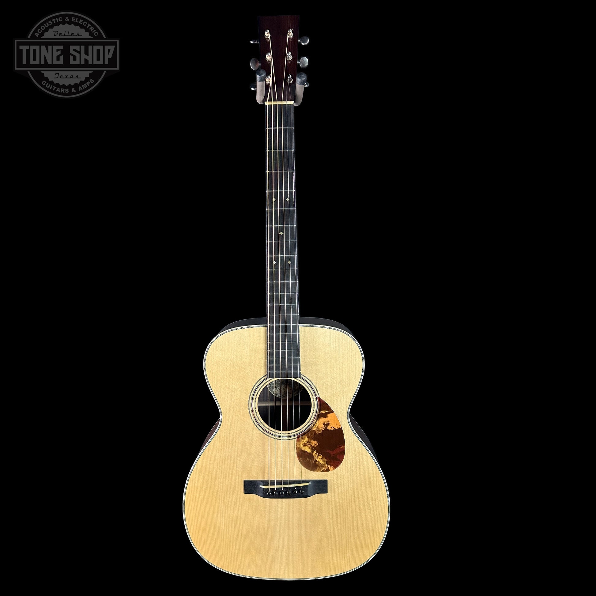 Acoustic guitar with a visible brand logo on a black background