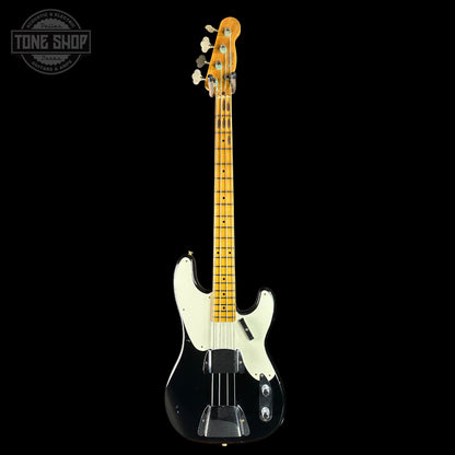 Electric bass guitar with a black body and on a black background, featuring the Tone Shop logo.