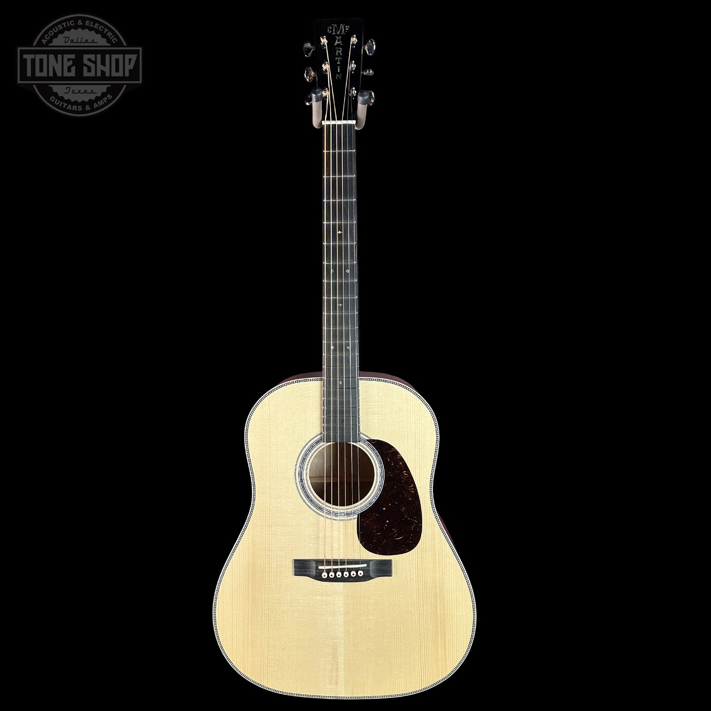 Acoustic guitar with a visible brand logo on a black background