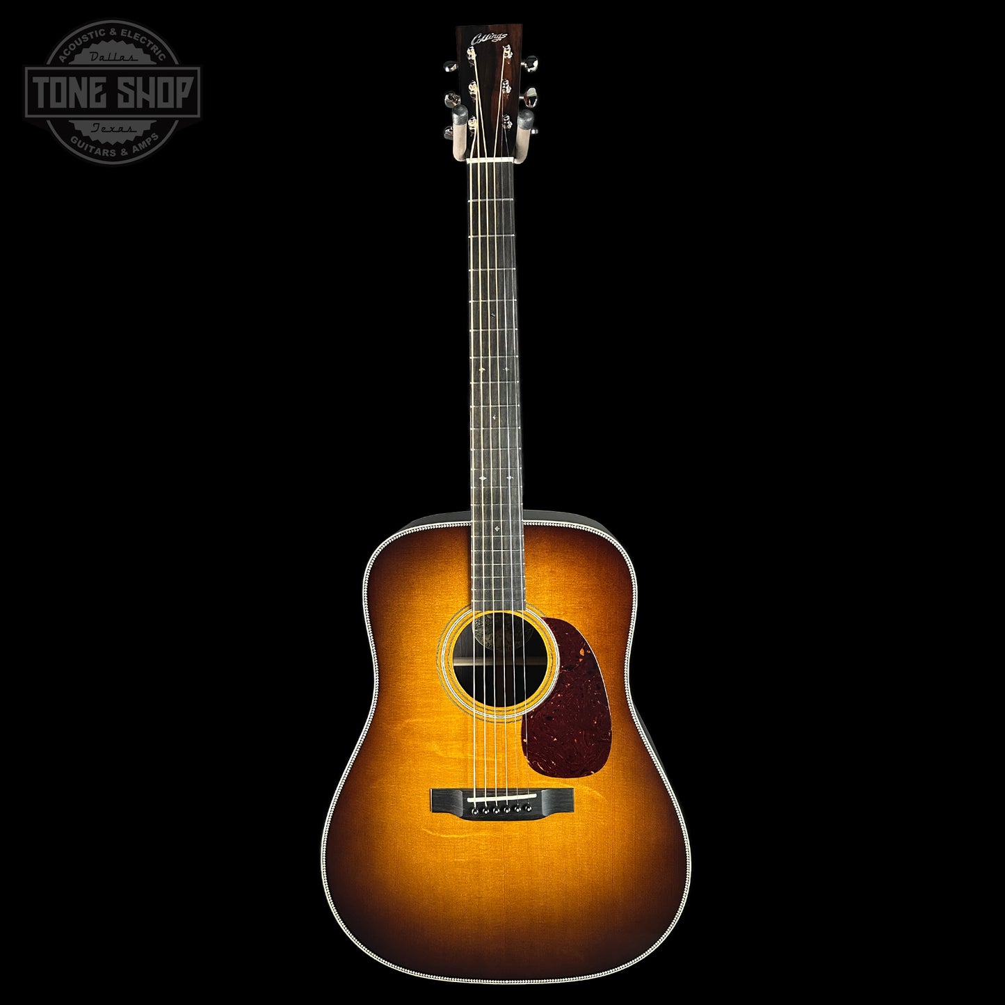 Acoustic guitar with a sunburst finish on a black background, featuring the Tone Shop logo.