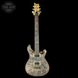Electric guitar with a wavy wood finish on a black background, featuring the Tone Shop logo.