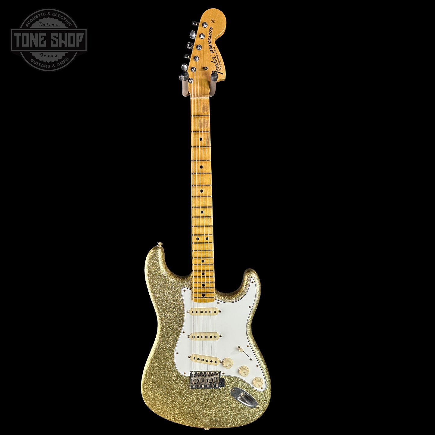 Gold glitter electric guitar with a white pickguard on a black background, featuring 'Tone Shop' logo.