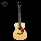 Acoustic guitar with a visible brand logo on a black background