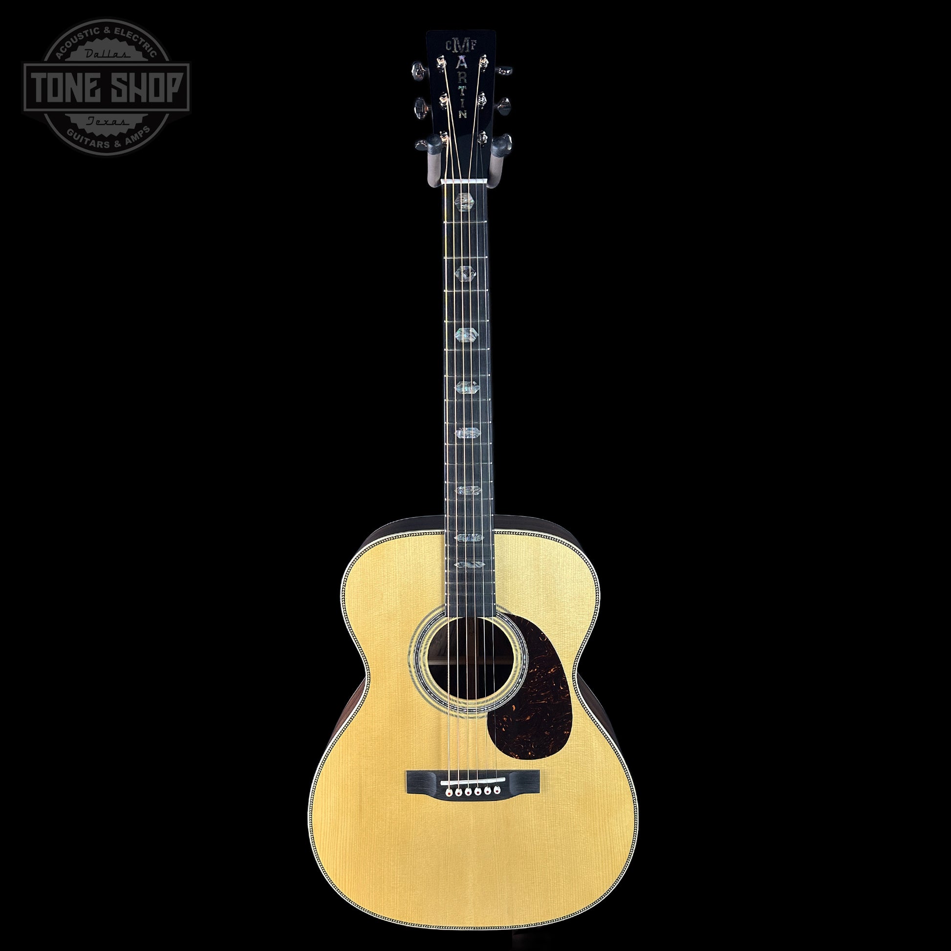 Acoustic guitar with a 'Tone Shop' logo in the corner