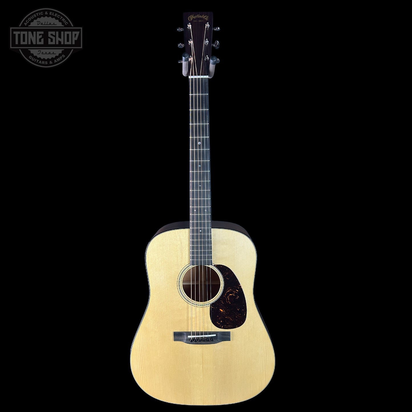 Acoustic guitar with a visible brand logo on a black background