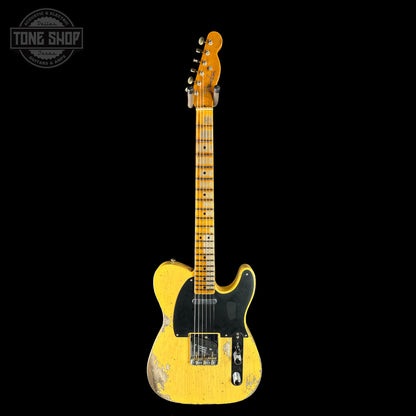 Yellow electric guitar with a worn finish on a black background, featuring 'Tone Shop' logo.