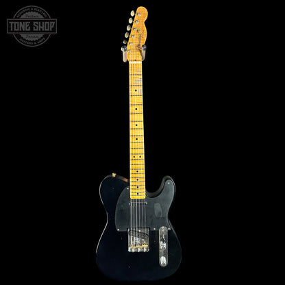 Black electric guitar with a visible brand logo on a black background