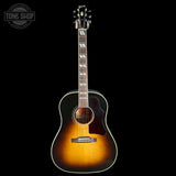 Acoustic guitar with a sunburst finish on a black background, featuring the Tone Shop logo.