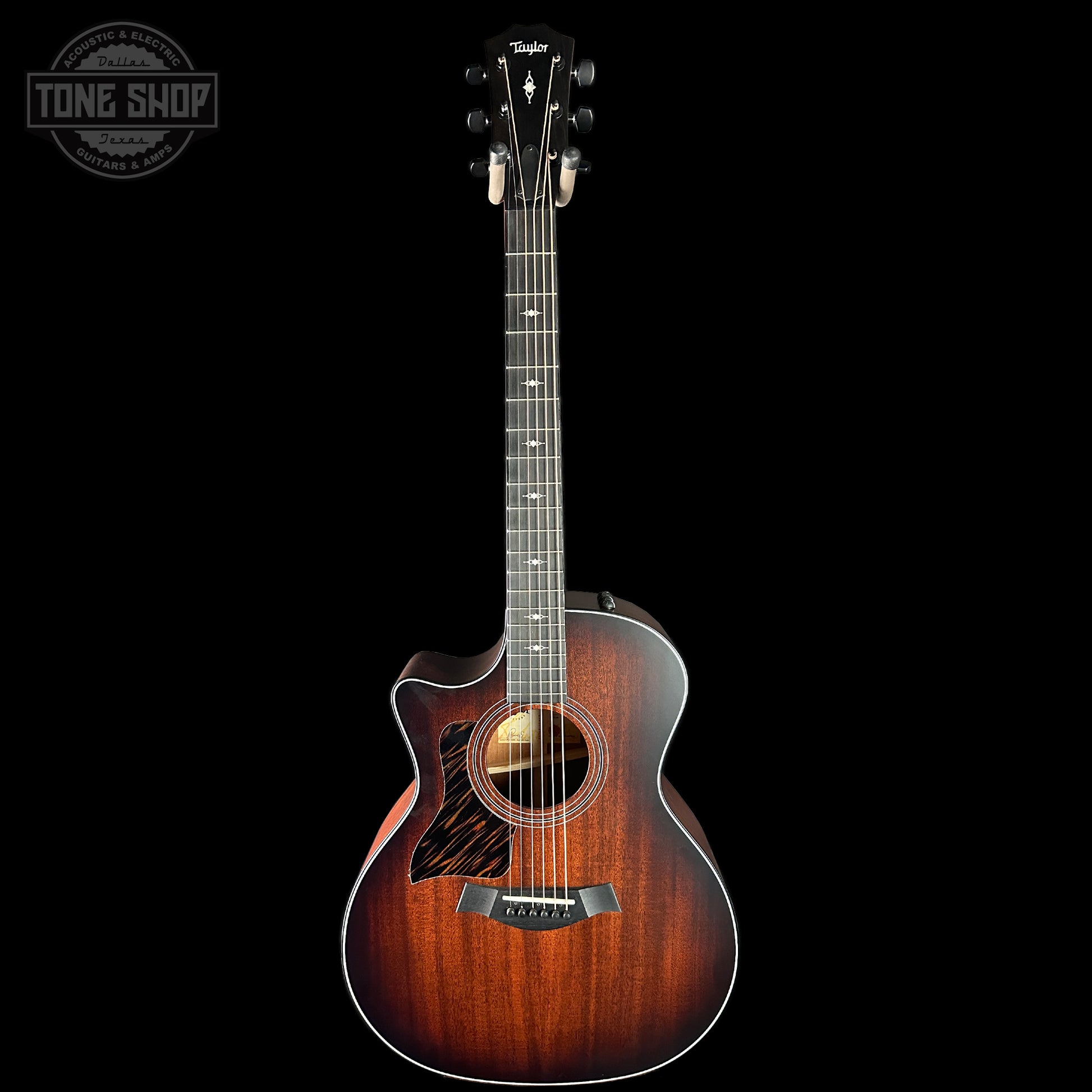 Acoustic guitar with a sunburst finish on a black background, featuring the Taylor logo.