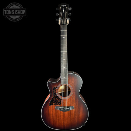 Acoustic guitar with a sunburst finish on a black background, featuring the Taylor logo.