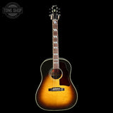 Acoustic guitar with a sunburst finish on a black background, featuring the Tone Shop logo.
