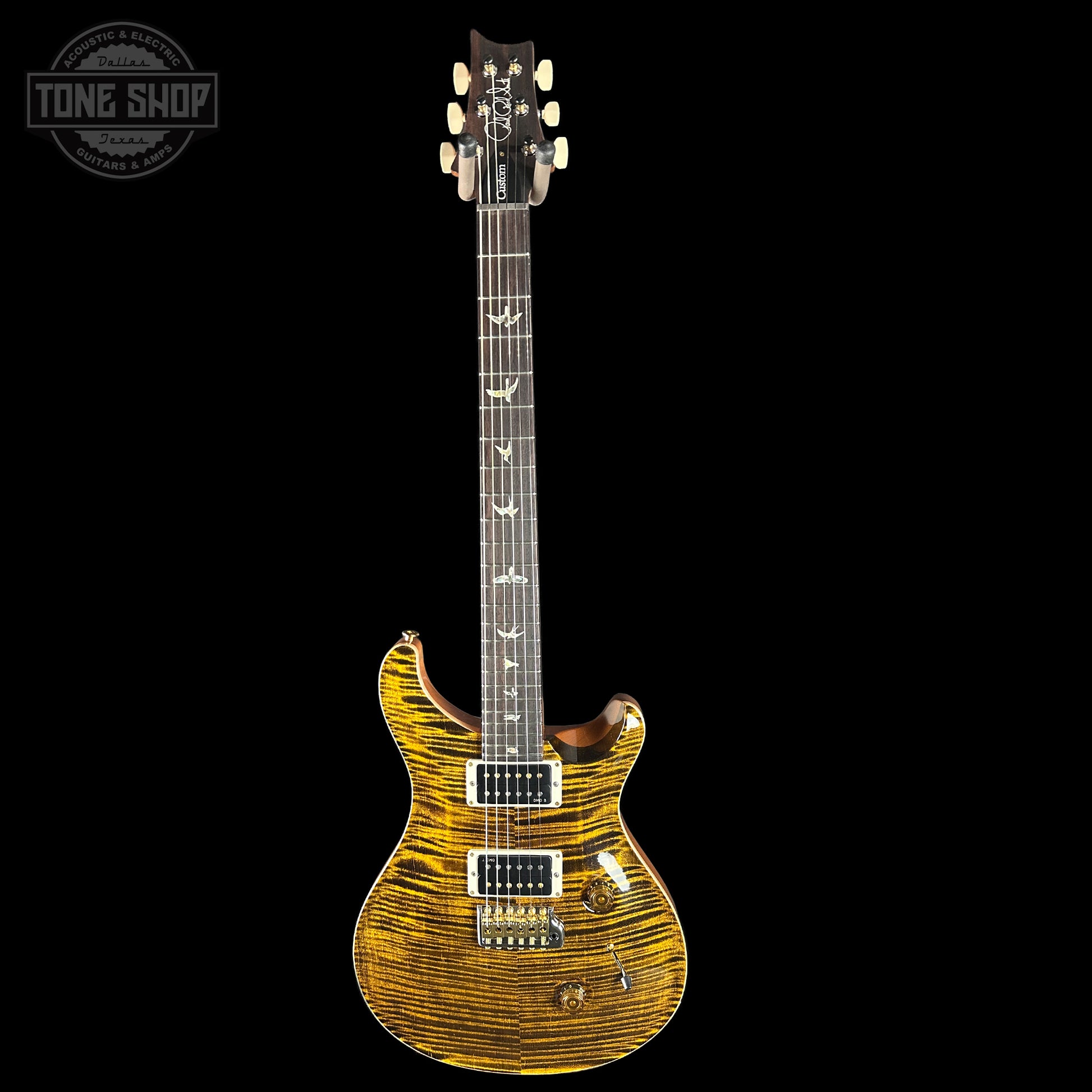 Electric guitar with a distinctive wood finish on a black background, featuring the Tone Shop logo.