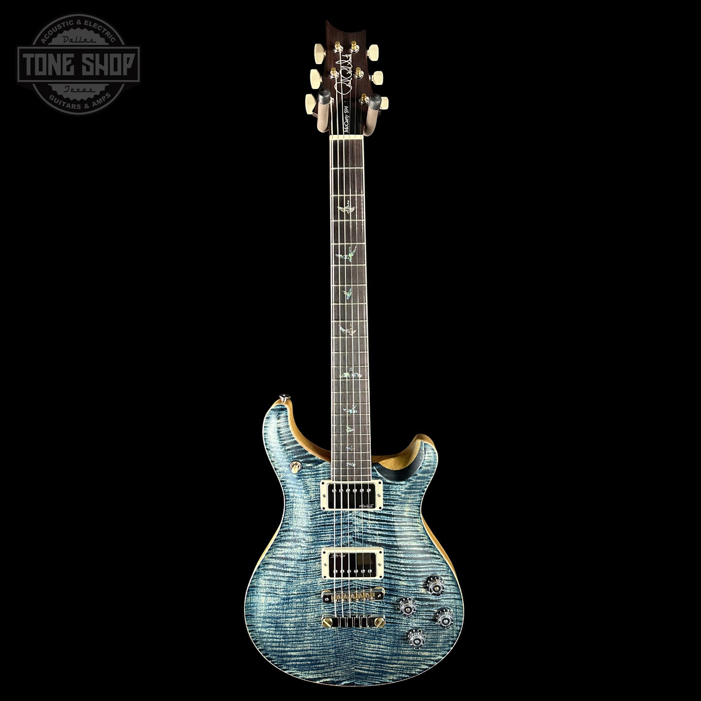 Blue electric guitar on a black background with 'Tone Shop' logo.