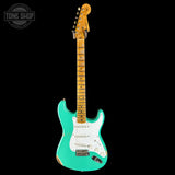 Turquoise electric guitar with a white pickguard on a black background, featuring 'Tone Shop' logo.