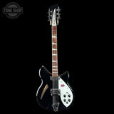 Electric guitar with a black and white design on a black background, featuring the Tone Shop logo.