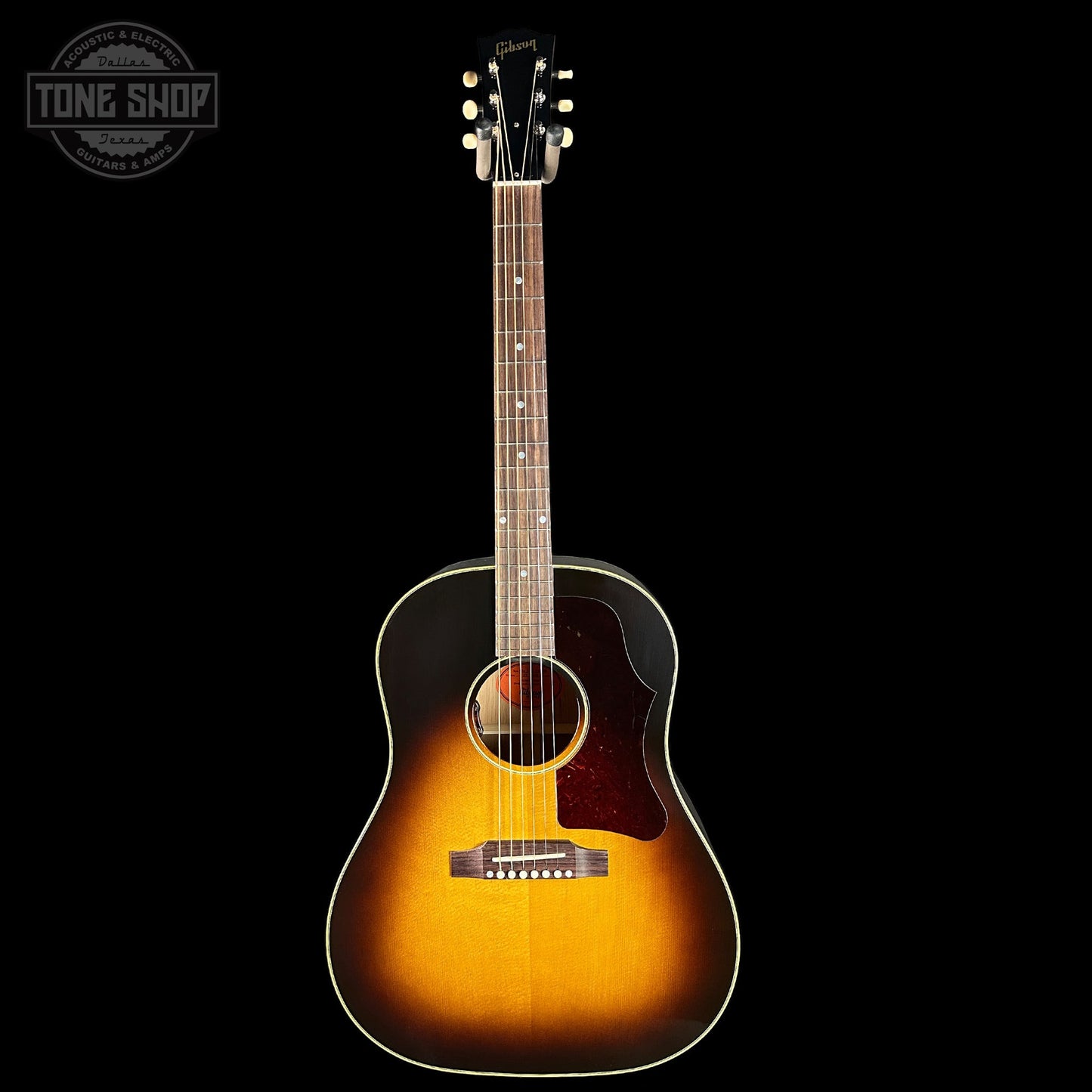 Acoustic guitar with a sunburst finish on a black background, featuring the Tone Shop logo.
