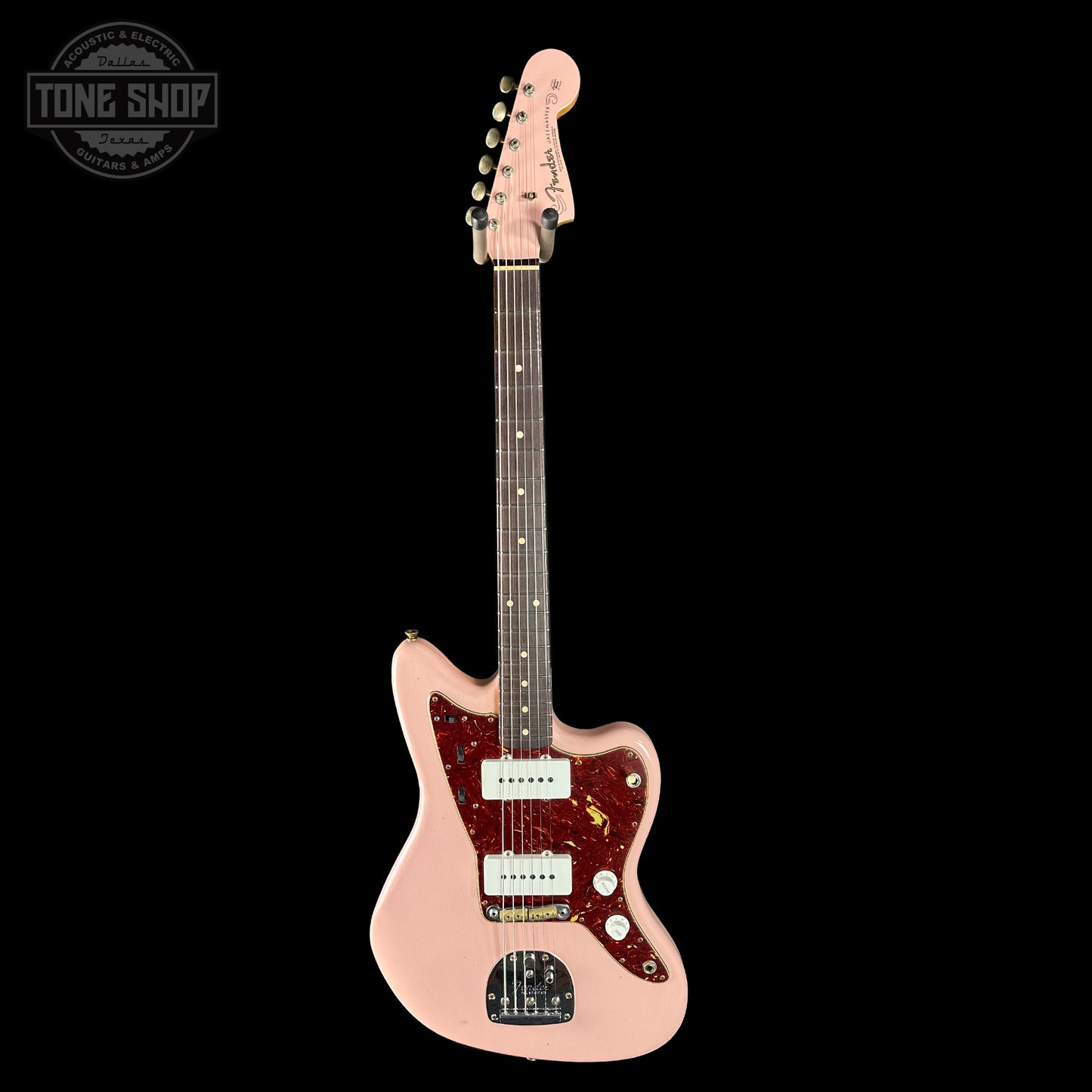 Pink electric guitar with a 'Tone Shop' logo in the corner