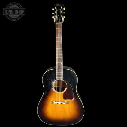 Acoustic guitar with a sunburst finish on a black background, featuring the Tone Shop logo.