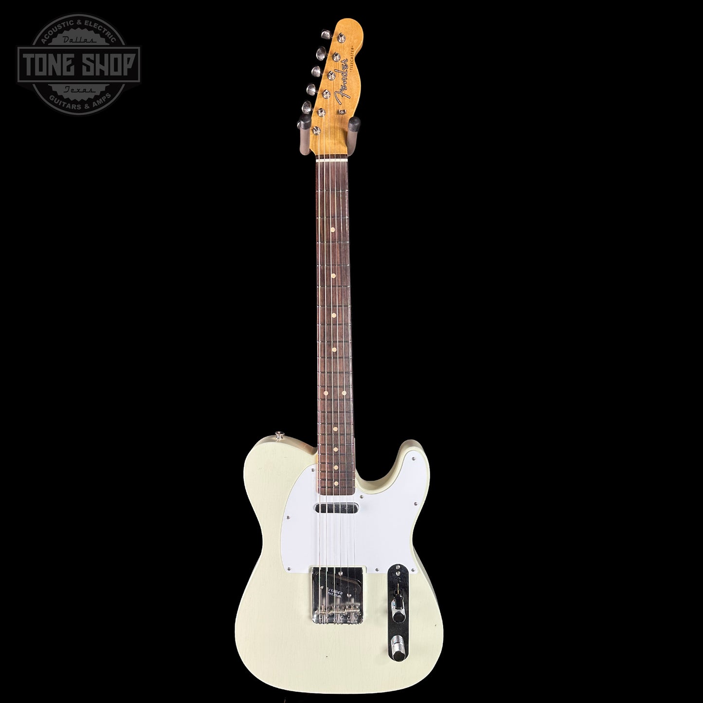 White electric guitar with a black background, featuring the Tone Shop logo.