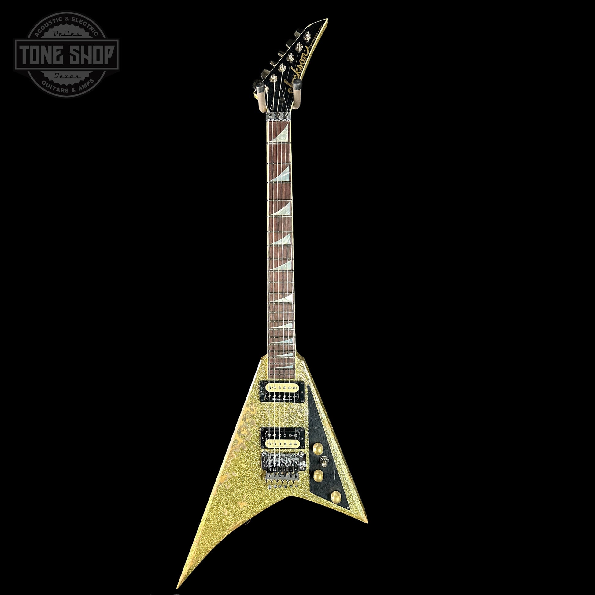 Gold electric guitar with a black background
