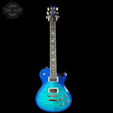 Blue electric guitar on a black background with 'Tone Shop' logo.