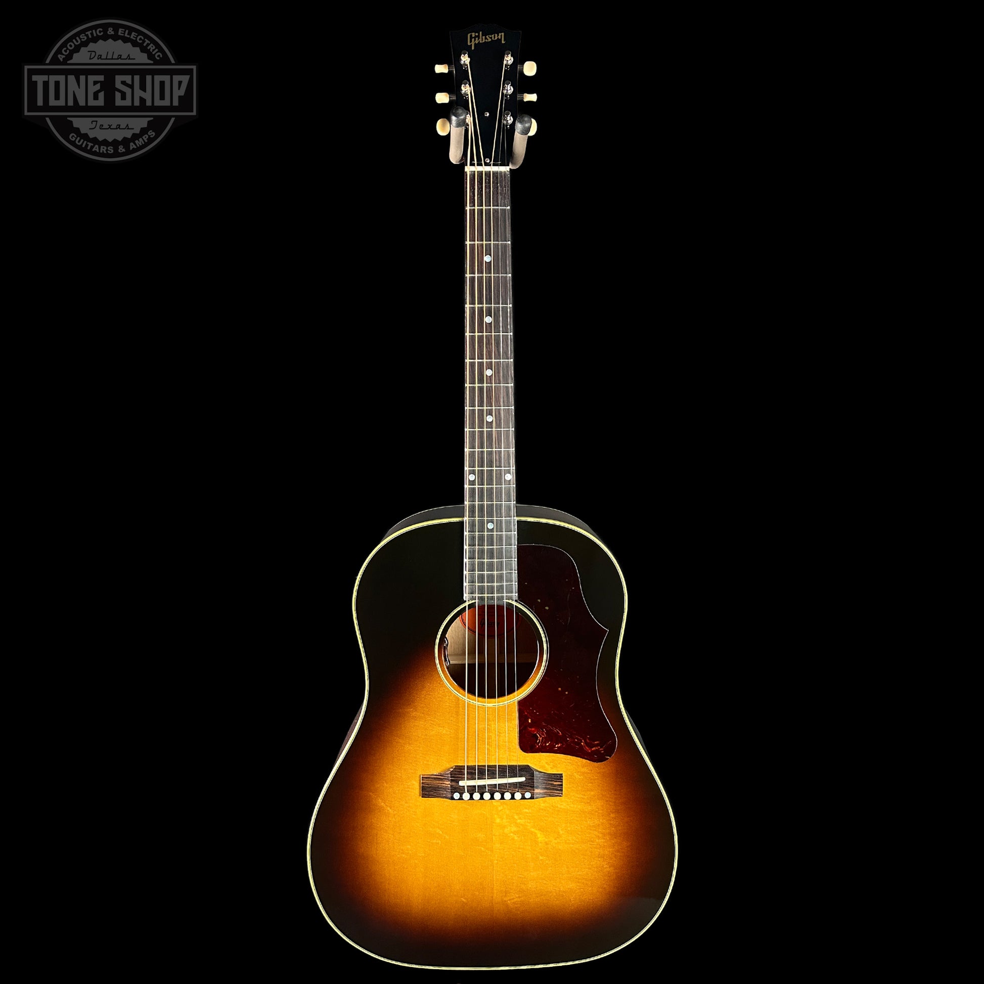 Acoustic guitar with a sunburst finish on a black background, featuring the Tone Shop logo.