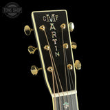 Close-up of a guitar headstock with 'C.F. Martin' branding on a black background.