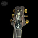 Guitar headstock with tuning pegs on a black background, featuring the Tone Shop logo.