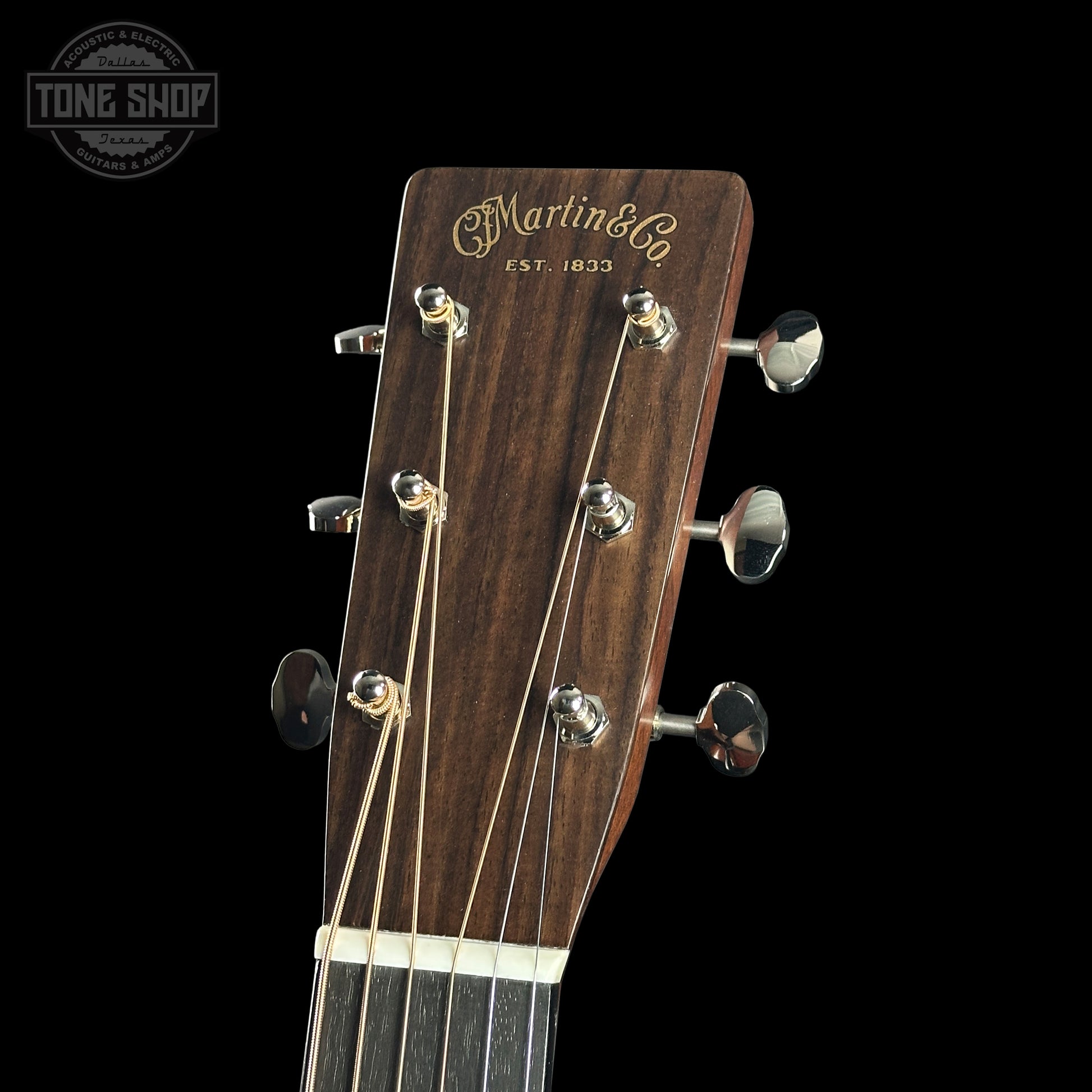 Close-up of a Martin guitar headstock with brand logo on a black background