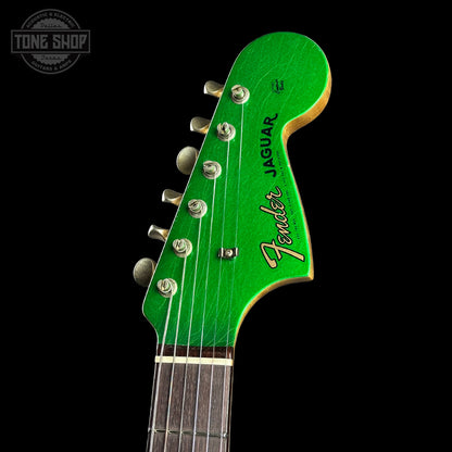 Close-up of a green Fender Jaguar guitar headstock on a black background