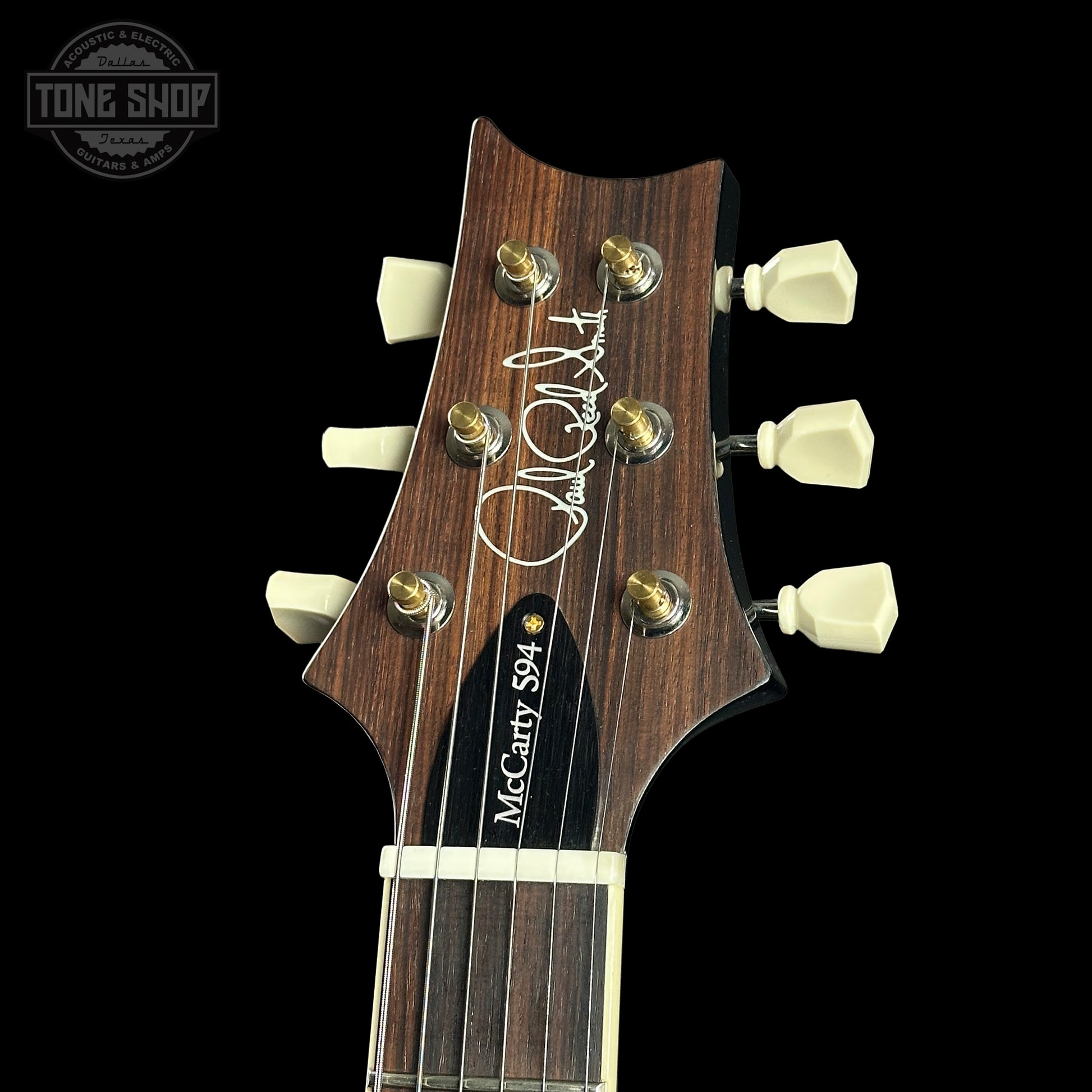 Guitar headstock with brand logo on a black background
