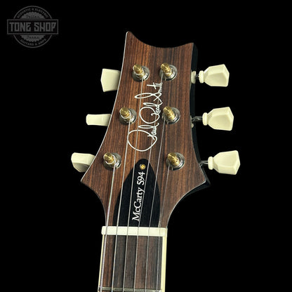 Guitar headstock with brand logo on a black background