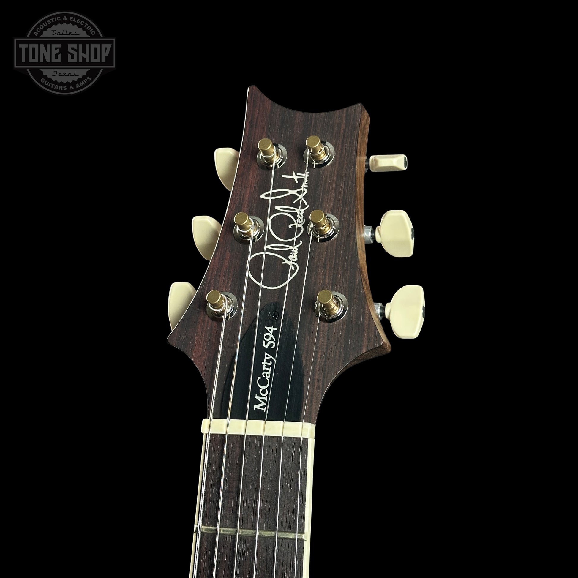 Guitar headstock with brand logo on a black background