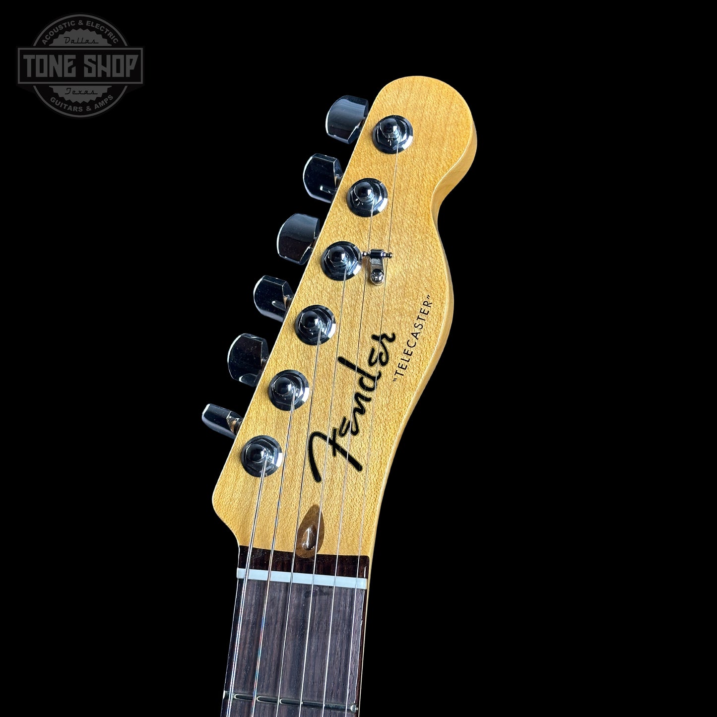 Fender headstock of a guitar on a black background