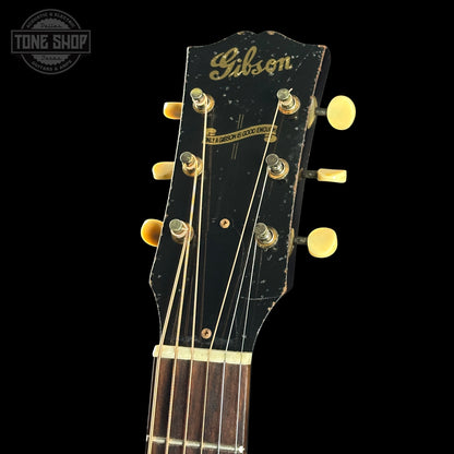 Gibson guitar headstock with visible wear on a black background