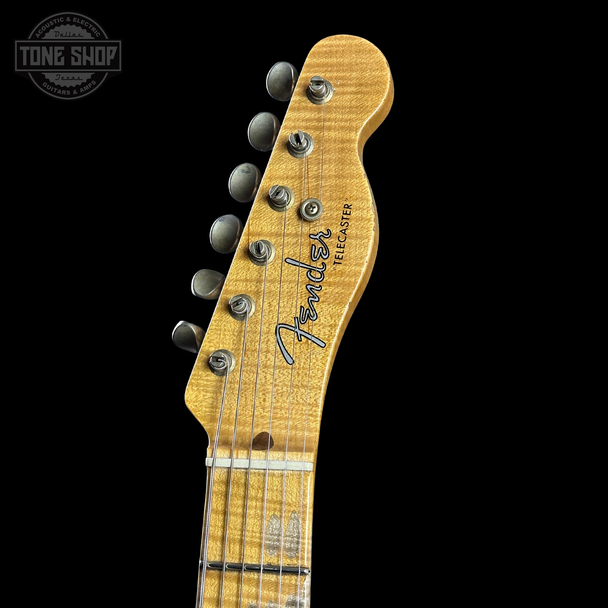 Close-up of a Fender Stratocaster guitar headstock on a black background