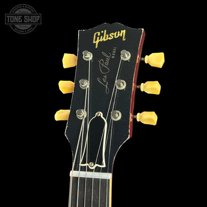 Gibson Les Paul guitar headstock with yellow tuning pegs on a black background