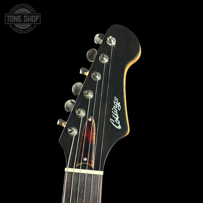 Close-up of a guitar headstock with 'Collings' logo on a black background
