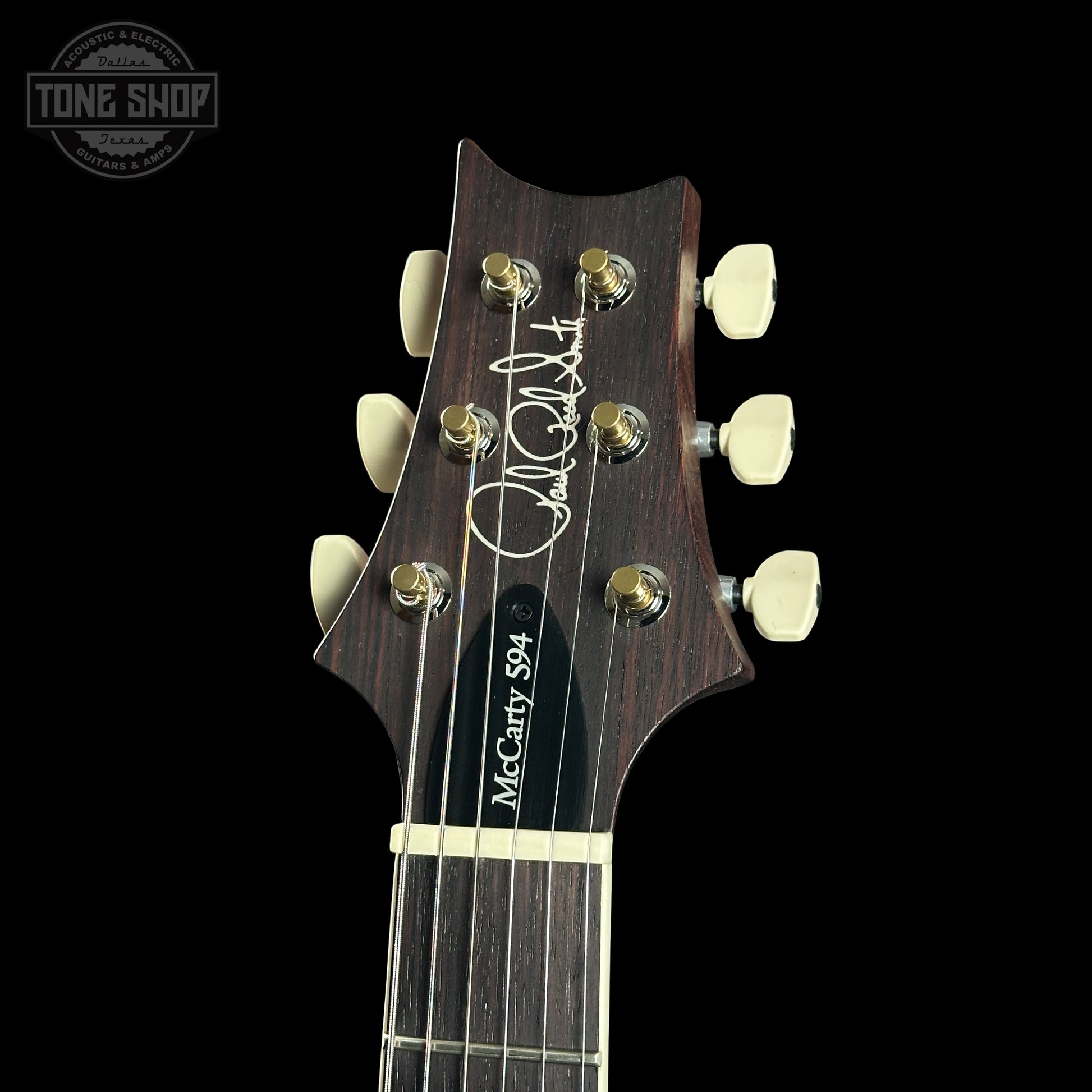 Guitar headstock with brand logo on a black background
