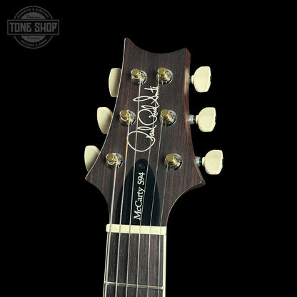 Guitar headstock with brand logo on a black background