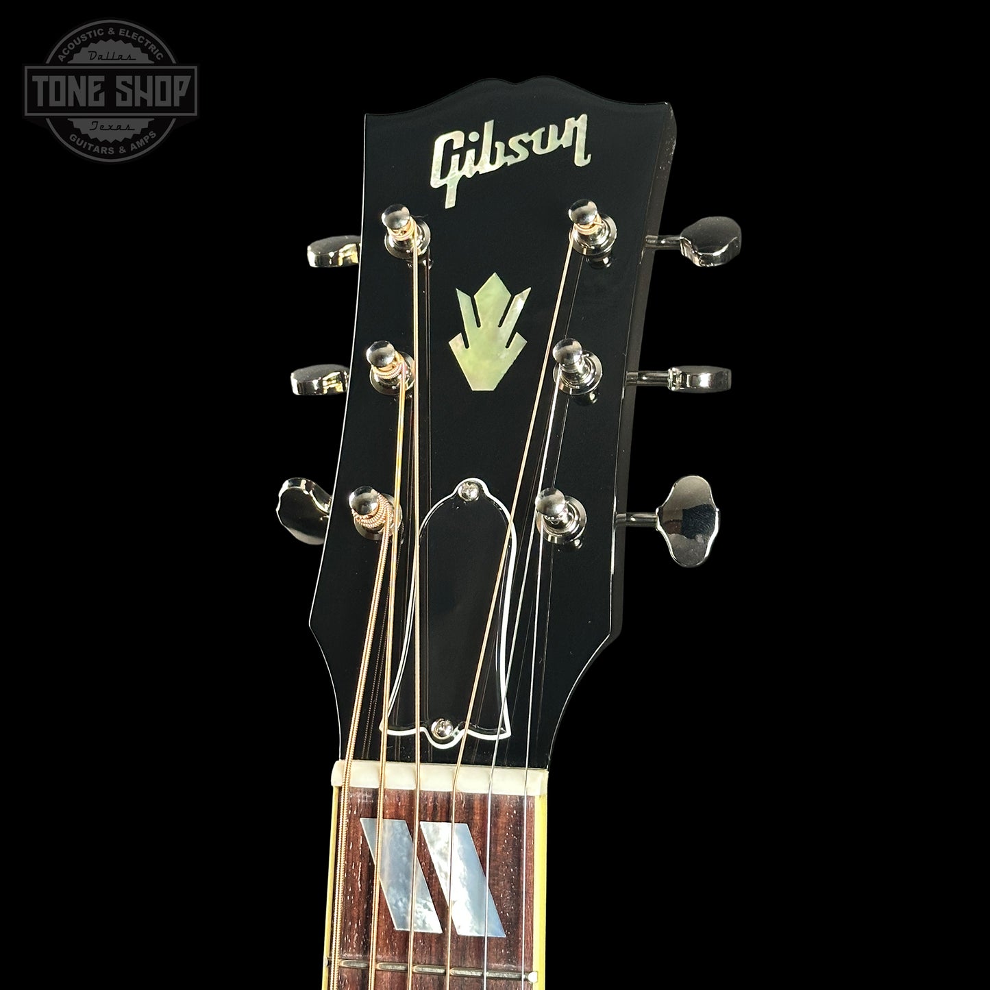 Gibson guitar headstock with brand logo on a black background