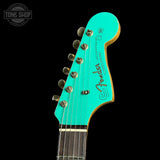 Turquoise guitar headstock with Fender logo on a black background