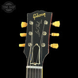 Gibson Les Paul guitar headstock with yellow tuning pegs on a black background