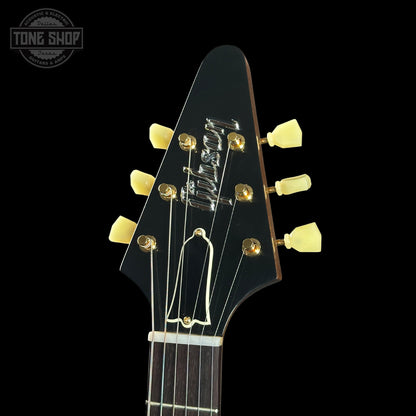 Close-up of a guitar headstock with 'Gibson' branding on a black background.