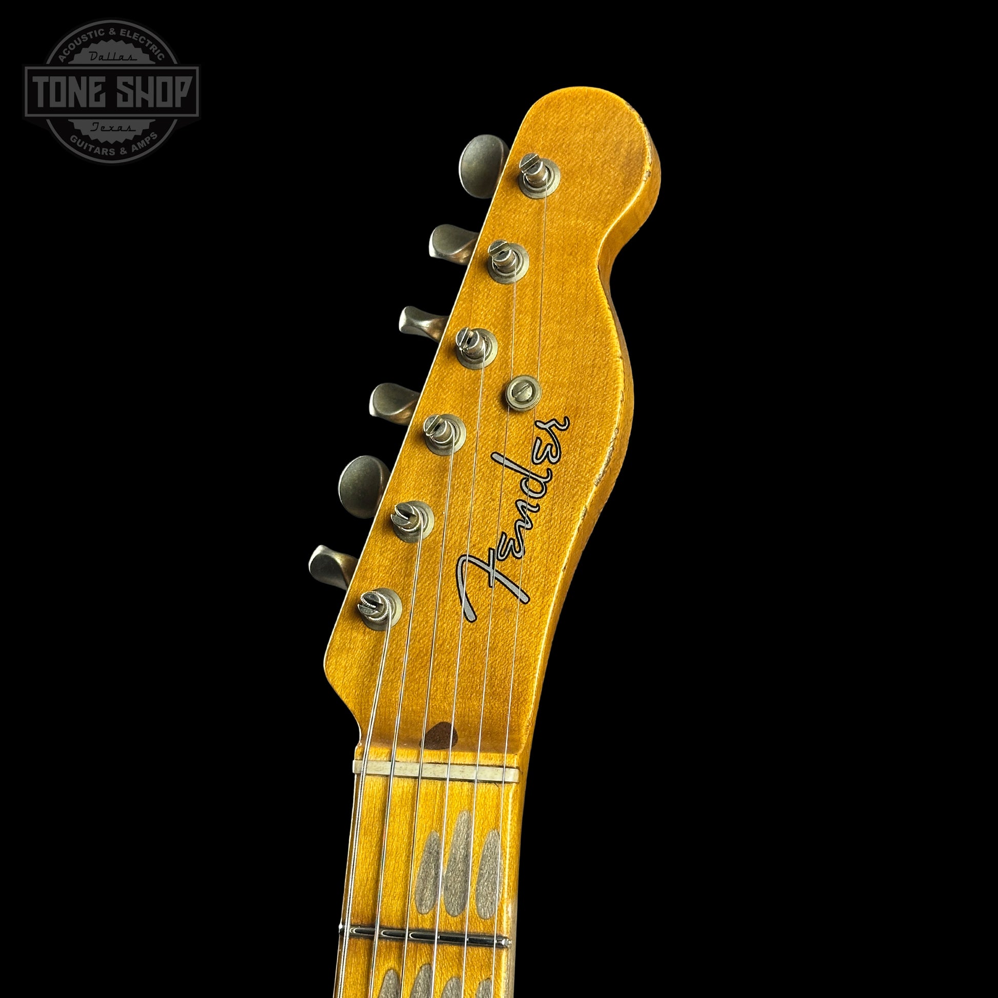 Close-up of a Fender guitar headstock on a black background