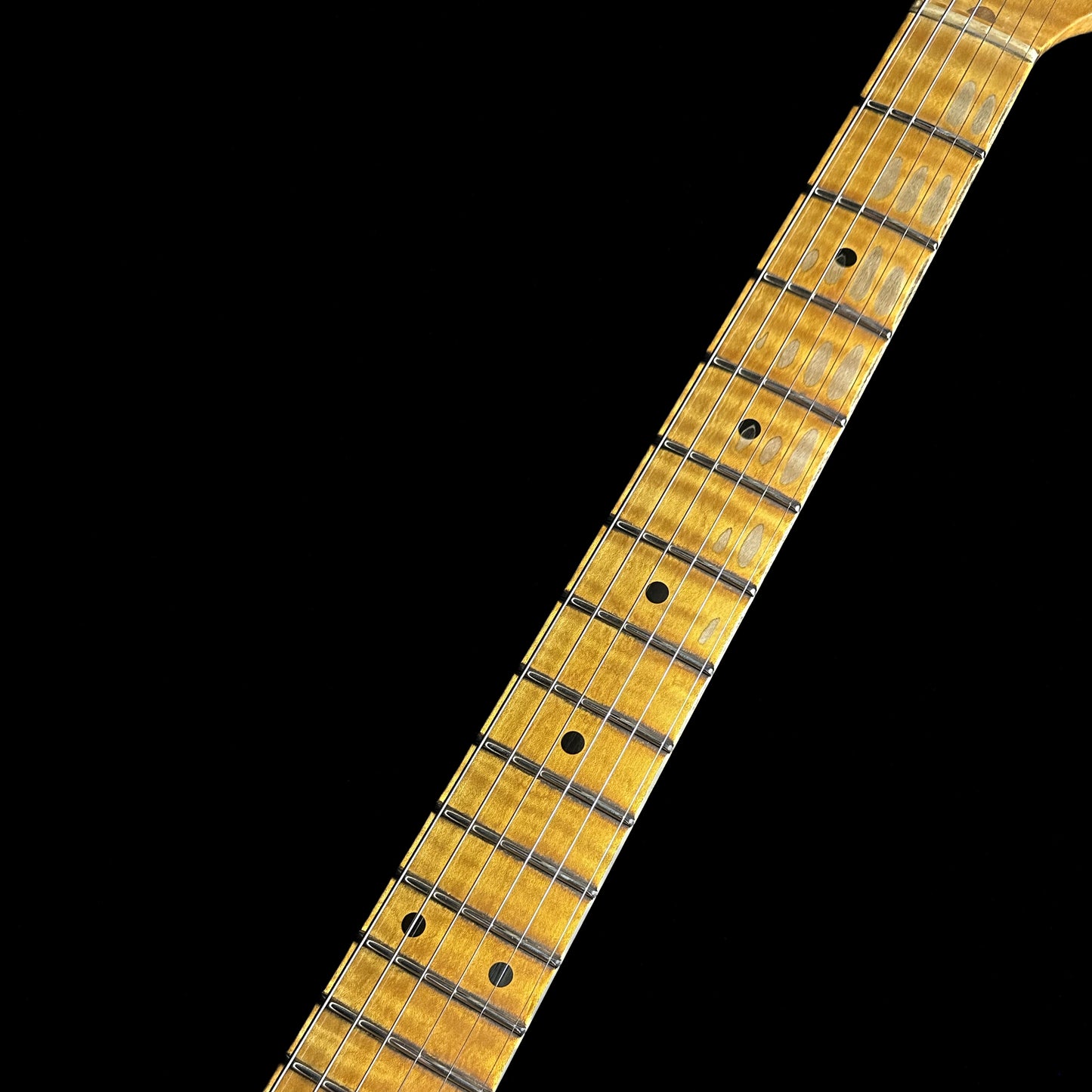 Closeup of Fender Custom Shop Limited Edition '55 "bone-tone" Strat - Relic Wide-Fade 2-color Sunburst fretboard.